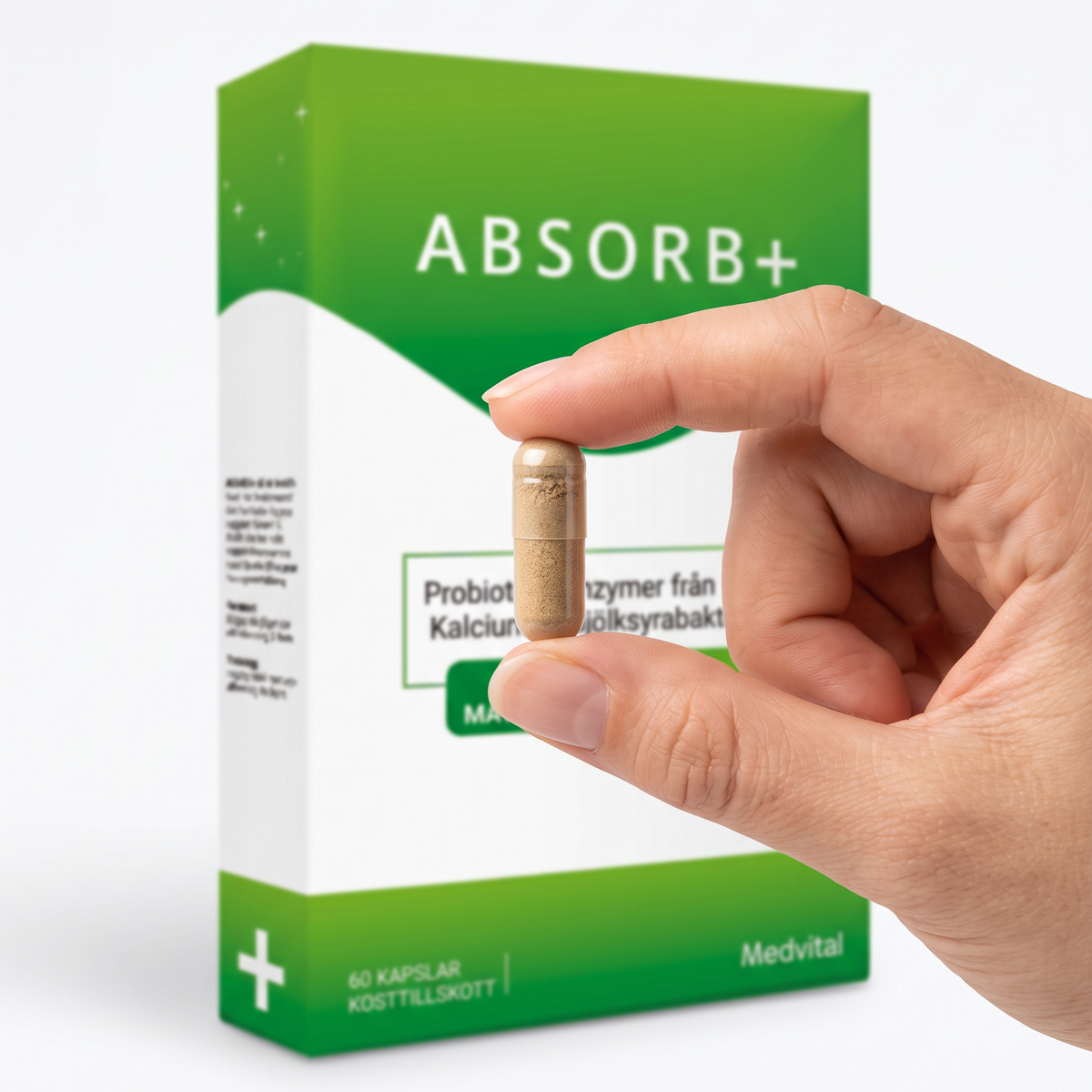En Absorb+-kapsel hålls mellan två fingrar framför förpackningen